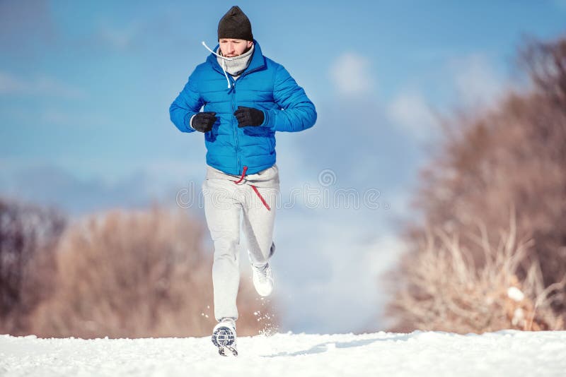 Fitness concept of a man running outdoor in snow on a cold winter day. Fitness concept of a man running outdoor in snow on a cold winter day