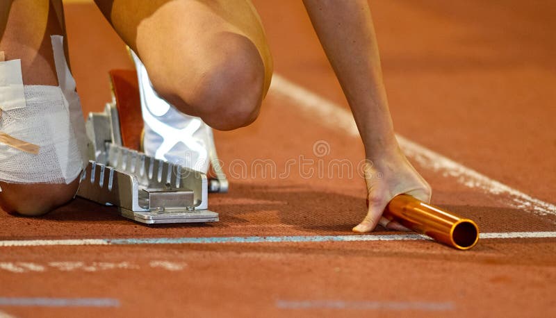 Corridore di relè nei blocchetti iniziare fotografia stock libera da diritti Corridore di relè nei blocchetti iniziare fotografia stock libera da diritti
