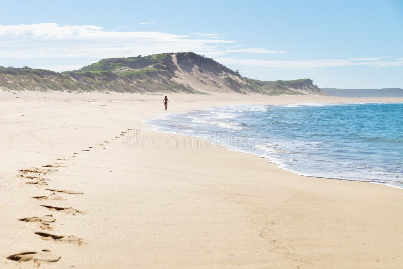 Corridore femminile alla spiaggia di Peterborough alla grande strada dell'oceano, Victoria, Australia immagini stock Corridore femminile alla spiaggia di Peterborough alla grande strada dell'oceano, Victoria, Australia immagini stock