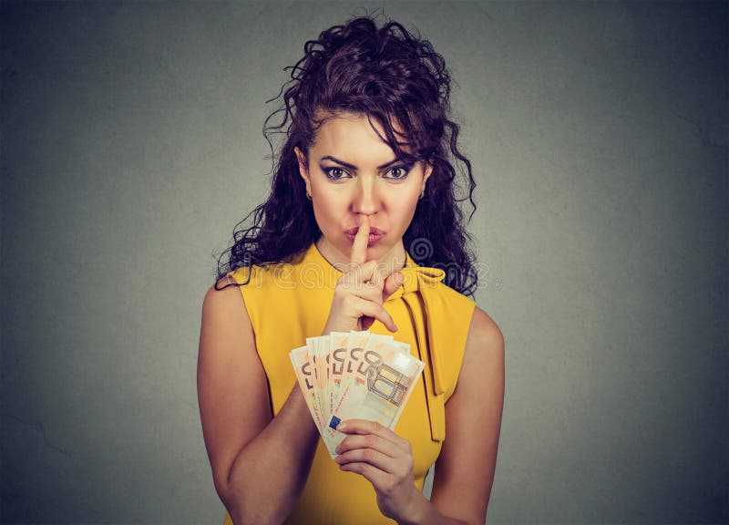 Corrupt, secretive woman with euro money showing shhh sign. On gray background. Bribery concept in politics royalty free stock photo Corrupt, secretive woman with euro money showing shhh sign. On gray background. Bribery concept in politics royalty free stock photo