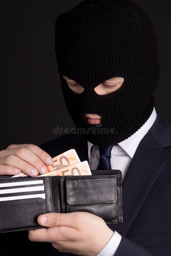 corruption concept - man in business suit and mask holding leather purse with euro banknotes