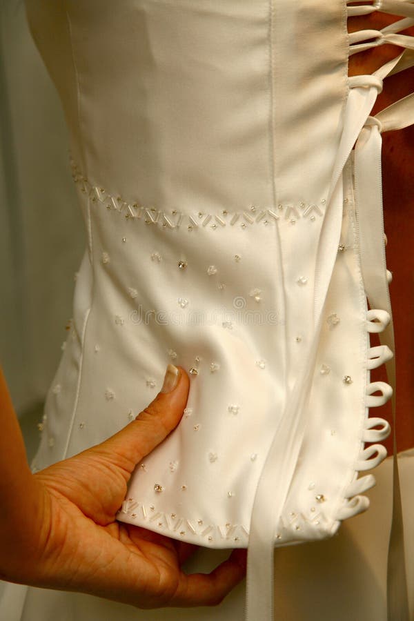 Bride holding corset of her wedding dress. Bride holding corset of her wedding dress