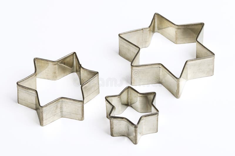Cortadores dados forma de três estrelas da cookie do Natal sobre o branco imagem de stock Cortadores dados forma de três estrelas da cookie do Natal sobre o branco imagem de stock