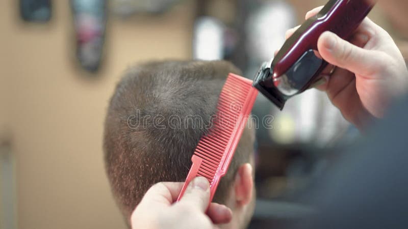 Corte de pelo masculino con afeitadora eléctrica. primer plano de corte de pelo hombre. hombre manos barbero afeitado hombre con a