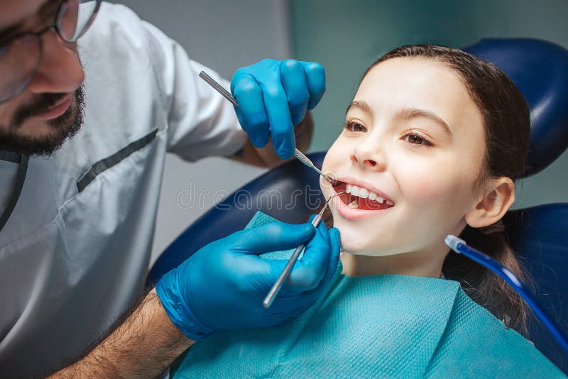 Corte la opinión el dentista de sexo masculino que hace el control para arriba de la boca de la muchacha Él utiliza las herramien fotografía de archivo libre de regalías Corte la opinión el dentista de sexo masculino que hace el control para arriba de la boca de la muchacha Él utiliza las herramien fotografía de archivo libre de regalías