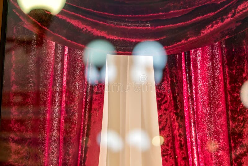Cortinas de teatro de terciopelo rojo a través de la ventana Luces reflectantes sobre el cristal imágenes de archivo libres de regalías Cortinas de teatro de terciopelo rojo a través de la ventana Luces reflectantes sobre el cristal imágenes de archivo libres de regalías