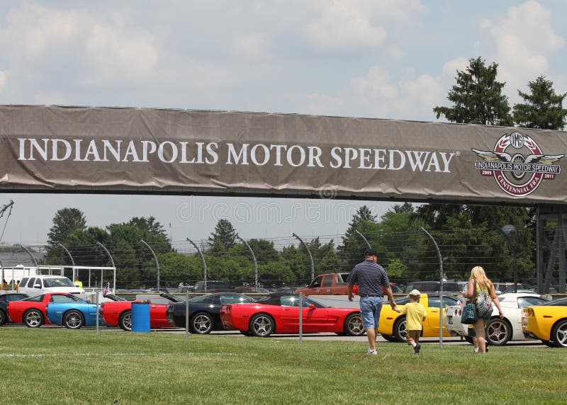 Family of three walking towards Colorful Corvettes in line at the Indianapolis Motor Speedway Parking Lot at Indy 500 Festival Community Day. Family of three walking towards Colorful Corvettes in line at the Indianapolis Motor Speedway Parking Lot at Indy 500 Festival Community Day.