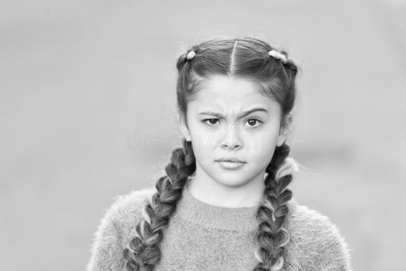 Cosa c'è che non va? Piccolo bambino con un aspetto sconcertato Piccolo bambino indossa trecce lunghe di bruna Bambino adorabile immagine stock Cosa c'è che non va? Piccolo bambino con un aspetto sconcertato Piccolo bambino indossa trecce lunghe di bruna Bambino adorabile immagine stock