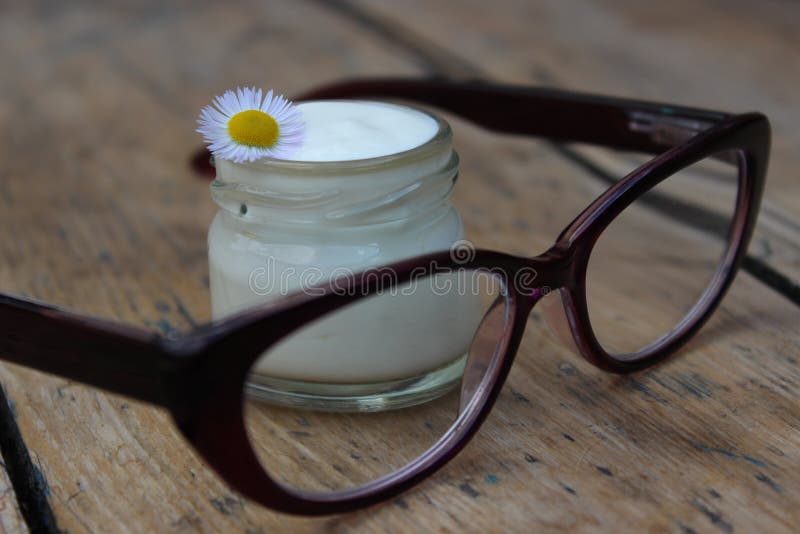 Cosmetic cream with chamomile flowers and glasses royalty free stock image Cosmetic cream with chamomile flowers and glasses royalty free stock image