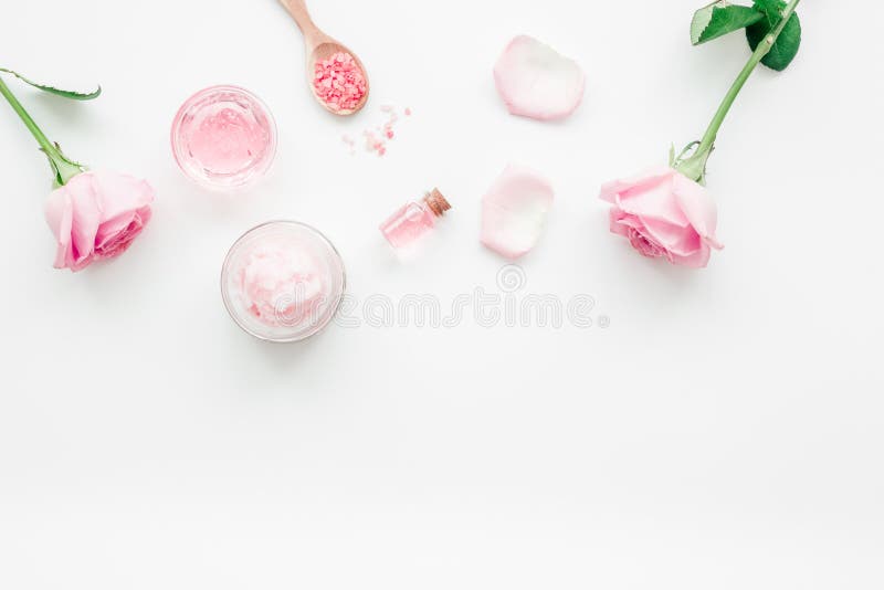 Cosmetic set with rose blossom and body cream on white desk background top view mock-up