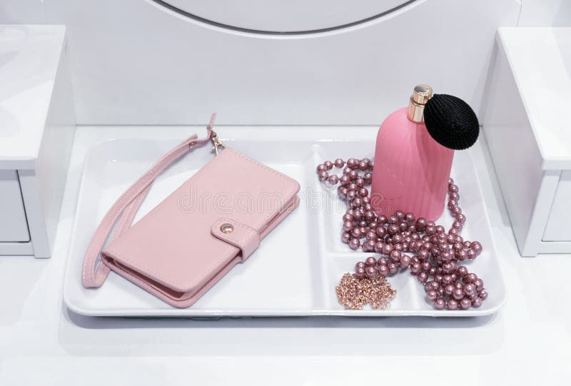 Cosmetic Table with Pink Clutch, Perfume and Pearl Beads Stock Image
