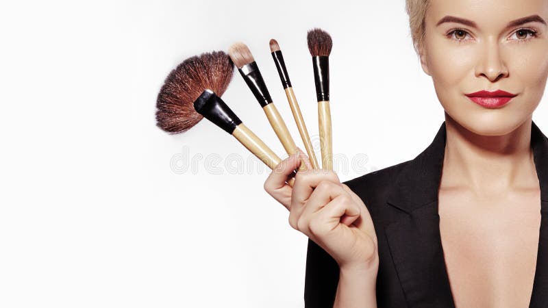Cosmetics and Beauty Treatment. Beautiful Girl with Make-up Brushes. Makeover. Makeup Artist Applying Visage