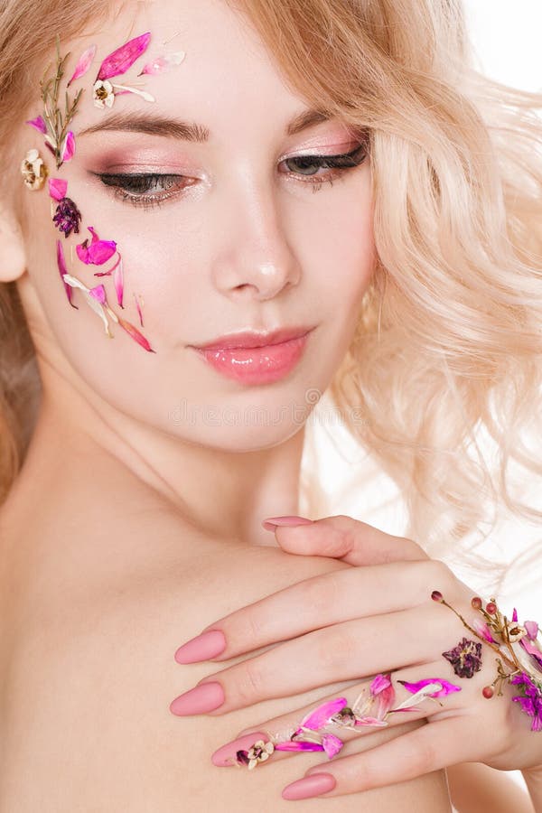 Cosmetics and manicure. Close-up portrait of attractive woman with dry flowers on her face, pastel color of nail design royalty free stock photography Cosmetics and manicure. Close-up portrait of attractive woman with dry flowers on her face, pastel color of nail design royalty free stock photography