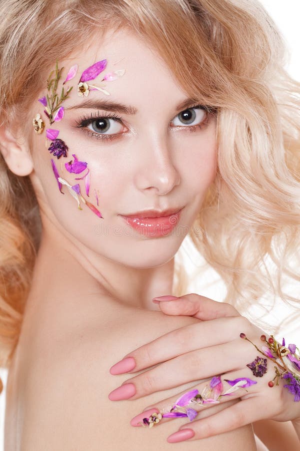 Cosmetics and manicure. Close-up portrait of attractive woman with dry flowers on her face, pastel color of nail design stock photo Cosmetics and manicure. Close-up portrait of attractive woman with dry flowers on her face, pastel color of nail design stock photo