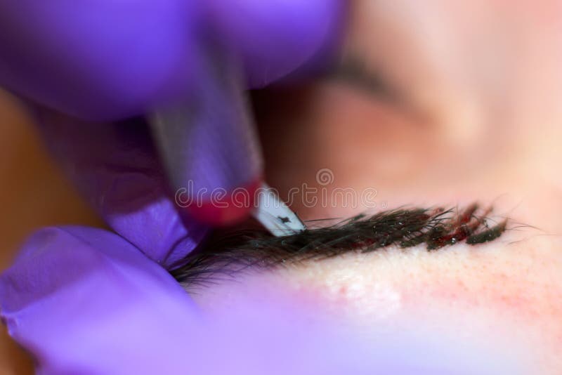 Cosmetologist applying permanent makeup on eyebrows stock photos Cosmetologist applying permanent makeup on eyebrows stock photos