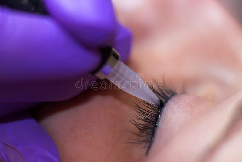 Cosmetologist, der dauerhaftes Make-up auf Augen anwendet lizenzfreies stockfoto Cosmetologist, der dauerhaftes Make-up auf Augen anwendet lizenzfreies stockfoto