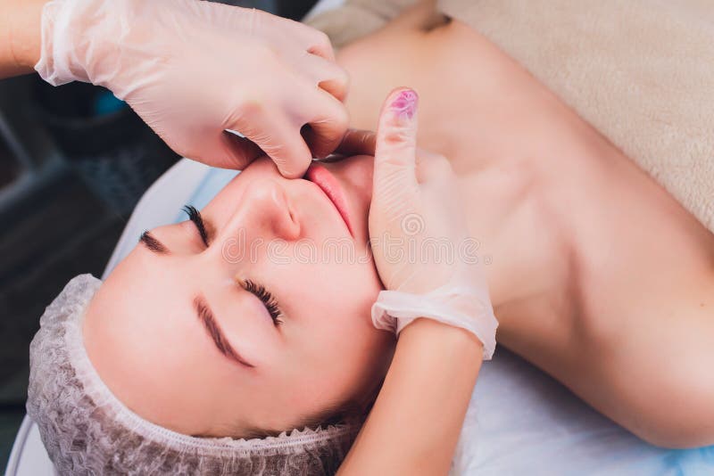 Cosmetologist maakt een mondmassage van de gezichtsspieren van de pati?nt