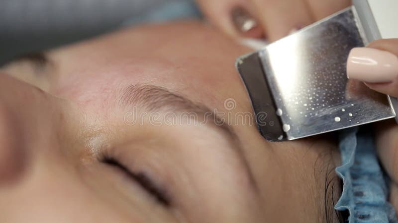 Cosmetologist makes ultrasonic cleansing facial. Cosmetologist makes video