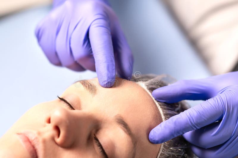 Cosmetologist, plast- kirurg eller doktor med patienten eller kunden Konsultation och plan för ansikts- kirurgi i sjukhus royaltyfria bilder