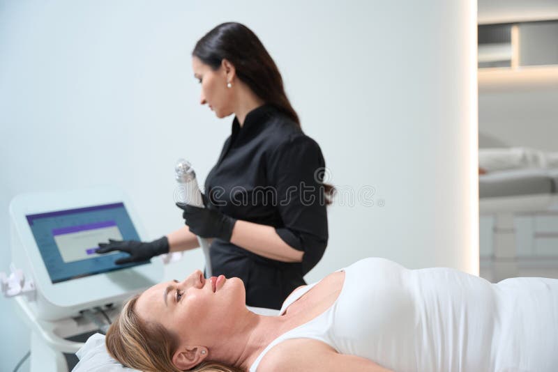 Cosmetologist Sets Up The Device For The Rf Lifting Procedure Stock