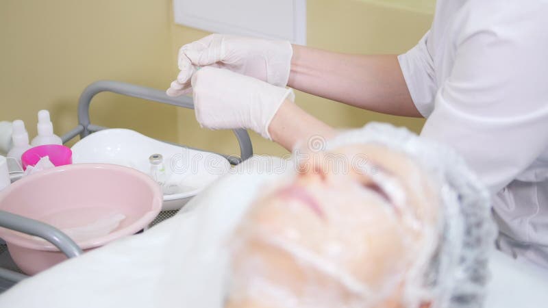 Cosmetologist stosuje śmietankę na klient twarzy robi osmetic procedur czyścić twarz w kosmetologii