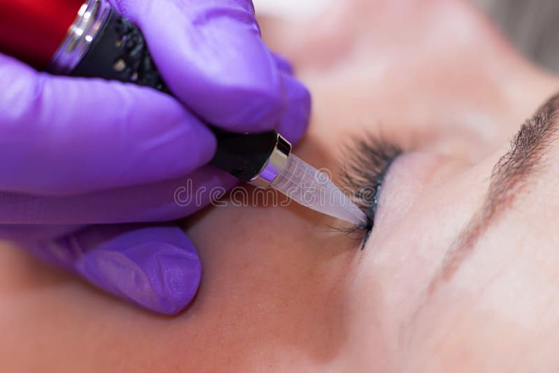 Cosmetologist που εφαρμόζει το μόνιμο makeup στα μάτια στοκ εικόνες Cosmetologist που εφαρμόζει το μόνιμο makeup στα μάτια στοκ εικόνες