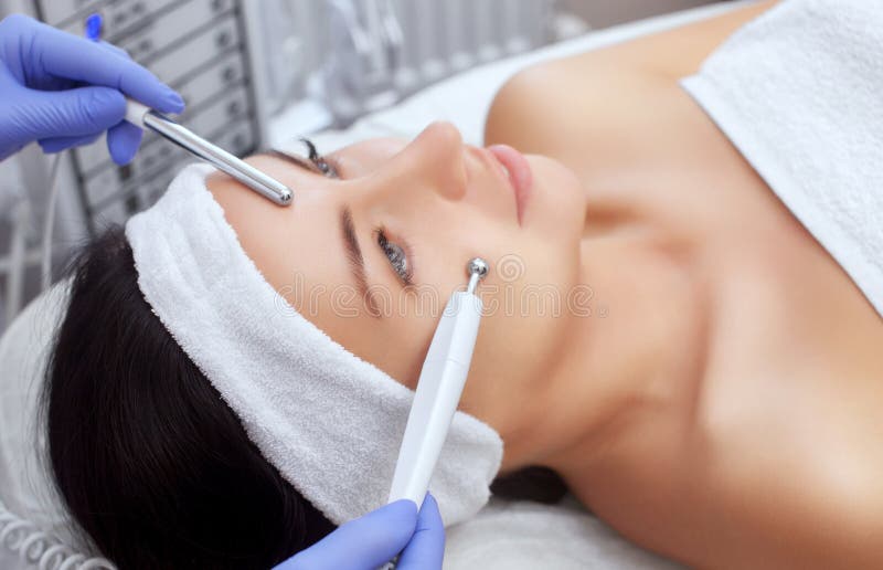 Cosmetologist делает прибором процедуру терапии красивого, молодой женщины Microcurrent в салоне красоты стоковые изображения Cosmetologist делает прибором процедуру терапии красивого, молодой женщины Microcurrent в салоне красоты стоковые изображения