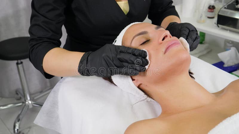 Cosmetologo che utilizza lana di cotone prepara la pelle video d archivio