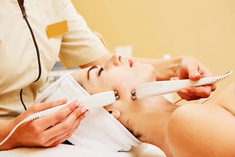 Cosmetology. Beautiful Woman At Spa Clinic Receiving Stimulating Electric Facial Treatment From Therapist. Closeup Of