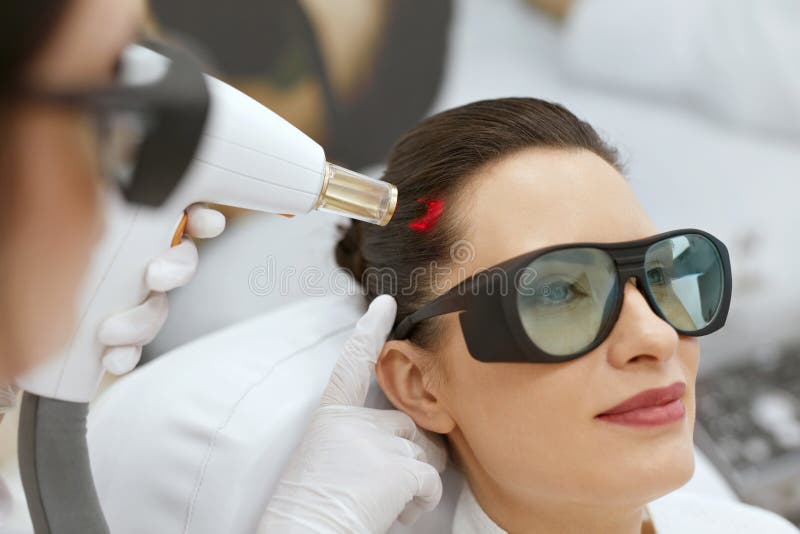 cosmétologie Femme au traitement de stimulation de laser de croissance de cheveux image libre de droits cosmétologie Femme au traitement de stimulation de laser de croissance de cheveux image libre de droits