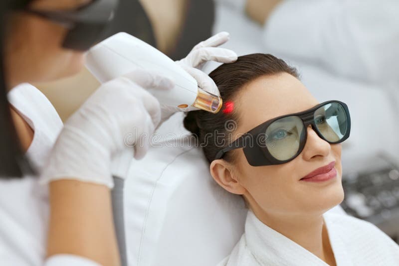 cosmétologie Femme au traitement de stimulation de laser de croissance de cheveux photos libres de droits cosmétologie Femme au traitement de stimulation de laser de croissance de cheveux photos libres de droits