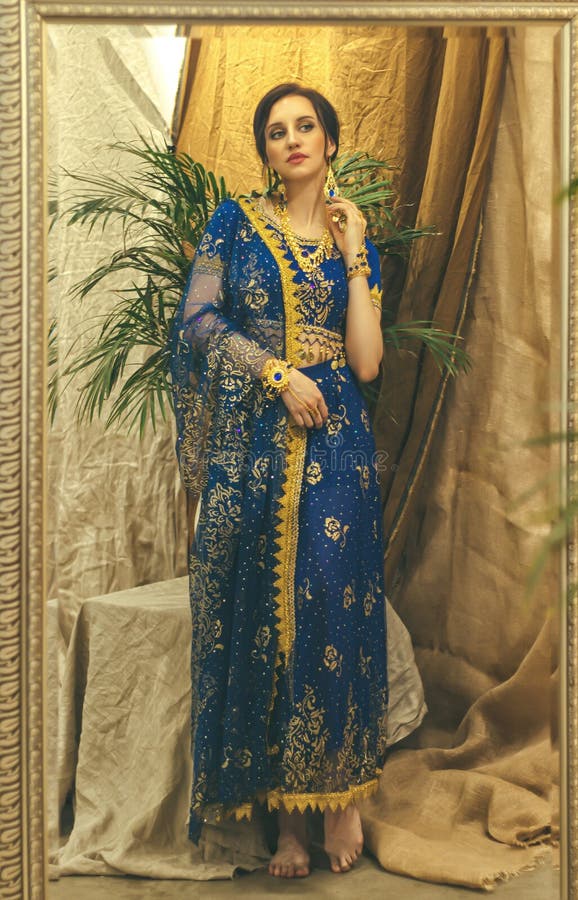 Cosplay De Hindú. Joven Hermosa Mujer Con Vestido Azul Indio Sari Closeup Está Mirando En El Espejo Imagen de archivo - Imagen de elegancia, morena: 185926081 Cosplay De Hindú. Joven Hermosa Mujer Con Vestido Azul Indio Sari Closeup Está Mirando En El Espejo Imagen de archivo - Imagen de elegancia, morena: 185926081