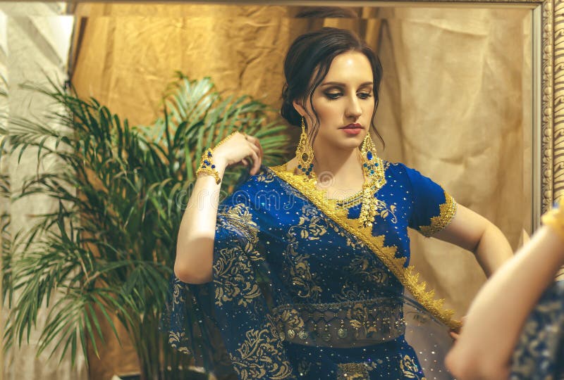 Cosplay De Hindú. Joven Hermosa Mujer Con Vestido Azul Indio Sari Closeup  Está Mirando En El Espejo Imagen de archivo - Imagen de traje, etnicidad:  185926255