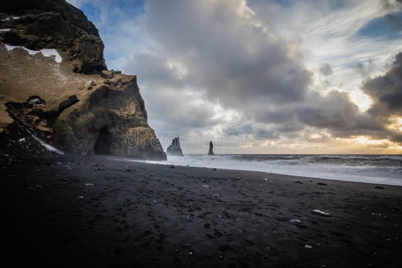 Costa hermosa del mar en Vik, Islandia con las nubes y las rocas impresionantes en el lado foto de archivo libre de regalías Costa hermosa del mar en Vik, Islandia con las nubes y las rocas impresionantes en el lado foto de archivo libre de regalías