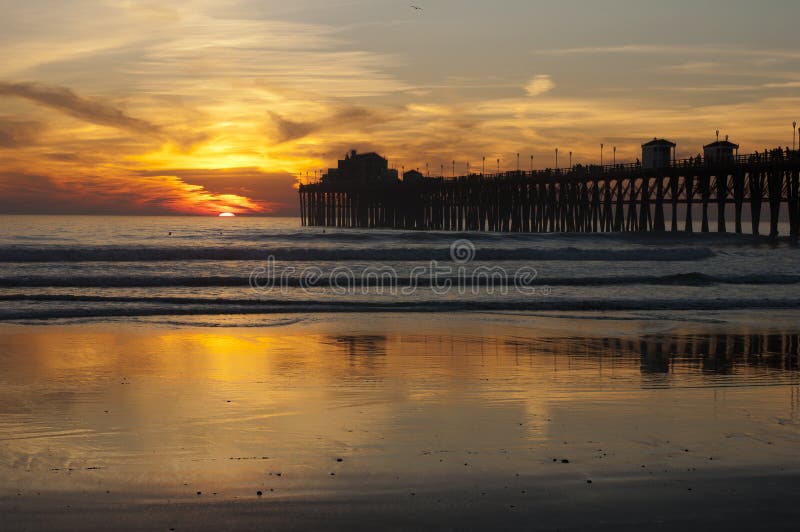 Orange sunset with silhouette of Oceanside, CA pier. Orange sunset with silhouette of Oceanside, CA pier.