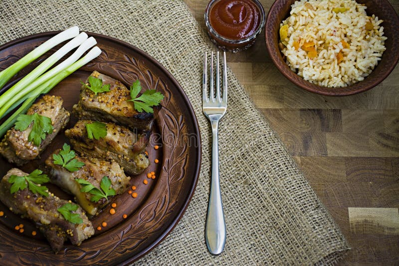 Costillas fritas deliciosas, vestidas con la salsa de la miel, adornada con verdes y verduras foto de archivo libre de regalías Costillas fritas deliciosas, vestidas con la salsa de la miel, adornada con verdes y verduras foto de archivo libre de regalías