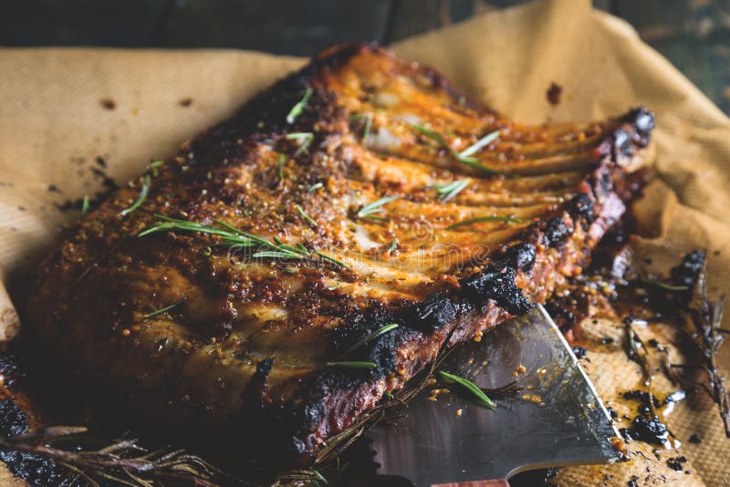 Costole al forno su una tavola e su uno scure di legno fotografie stock