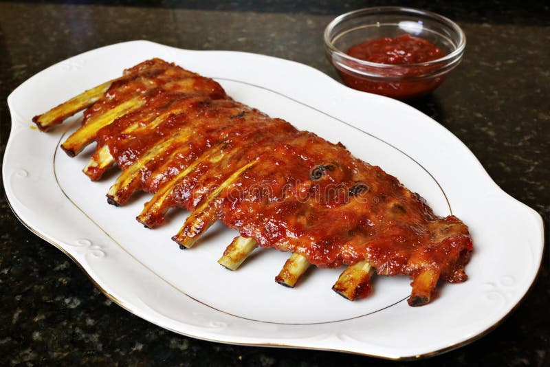 Costole di carne di maiale al forno con il barbecue o la salsa del BBQ fotografie stock Costole di carne di maiale al forno con il barbecue o la salsa del BBQ fotografie stock