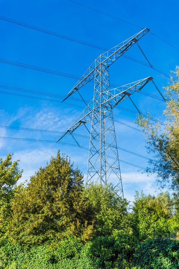 Costruzione d'acciaio della torre di potere di elettricità in un paesaggio della natura con cielo blu fotografia stock Costruzione d'acciaio della torre di potere di elettricità in un paesaggio della natura con cielo blu fotografia stock