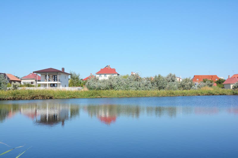 Costruzione della Camera con molti case e cottage sulla banca del lago con la bella vista fotografia stock libera da diritti Costruzione della Camera con molti case e cottage sulla banca del lago con la bella vista fotografia stock libera da diritti