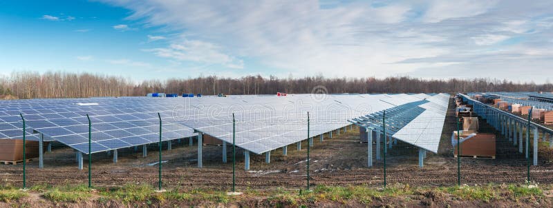 Part of ground-mounted solar power station with fixed photovoltaic panels during construction on a background of sky at late autumn. Part of ground-mounted solar power station with fixed photovoltaic panels during construction on a background of sky at late autumn