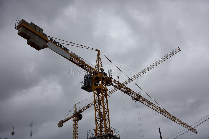 Costruzione di gru a cielo nuvoloso in un nuovo cantiere di costruzione in centro immagine stock Costruzione di gru a cielo nuvoloso in un nuovo cantiere di costruzione in centro immagine stock