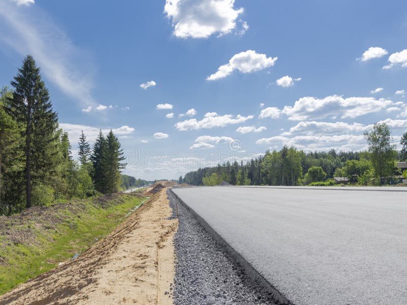 Costruzione di una strada asfaltata lunga in Russia fotografia stock libera da diritti Costruzione di una strada asfaltata lunga in Russia fotografia stock libera da diritti