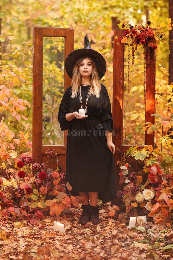 Costume Da Strega E Cappello Che Si Guardano Misteriosamente in Mano a Una  Candela Fotografia Stock - Immagine di contro, sfondo: 230214504