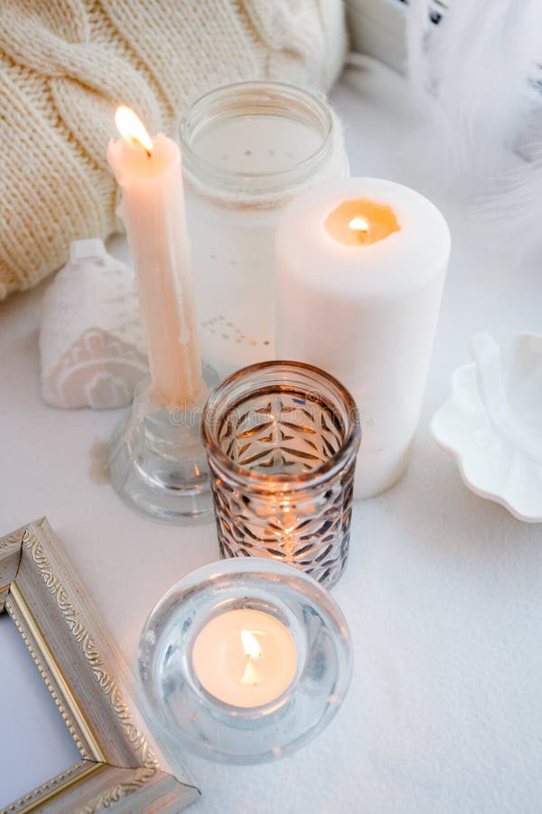 Cosy cozy and soft winter spring white monochrome background, knitted pillow and candles on windowsill board. Christmas holidays, stock image Cosy cozy and soft winter spring white monochrome background, knitted pillow and candles on windowsill board. Christmas holidays, stock image