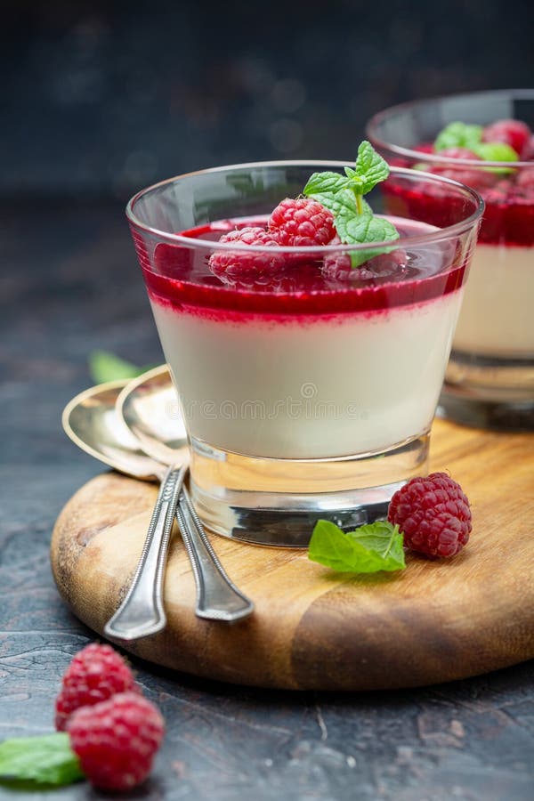 Cotta van vanillepanna met bessensaus en framboos stock foto Cotta van vanillepanna met bessensaus en framboos stock foto