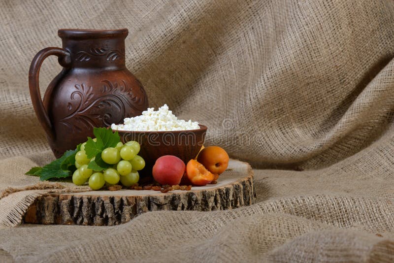 Cottage cheese in a clay dish, milk, grape, apricots on wooden background. stock image Cottage cheese in a clay dish, milk, grape, apricots on wooden background. stock image