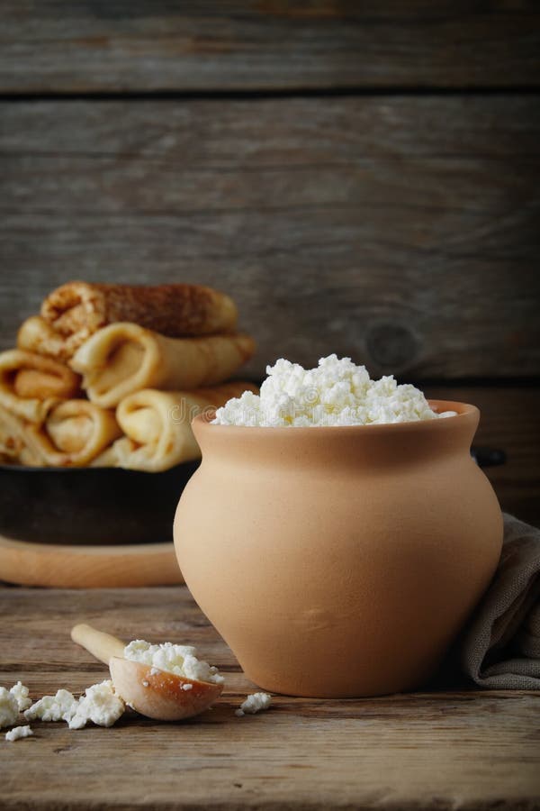 Cottage cheese in clay pot. and pancakes. Copy space for text.