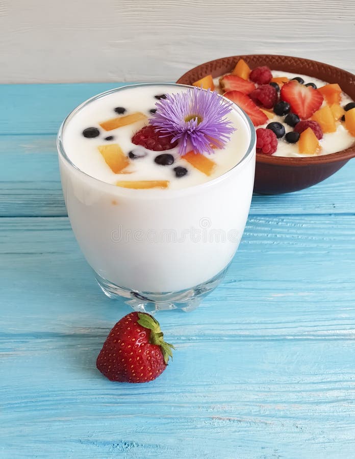 Cottage cheese healthy raspberry yogurt, strawberry, apricot, blueberry on a blue background, flower. Cottage cheese yogurt, strawberry, apricot, blueberry on a stock images Cottage cheese healthy raspberry yogurt, strawberry, apricot, blueberry on a blue background, flower. Cottage cheese yogurt, strawberry, apricot, blueberry on a stock images