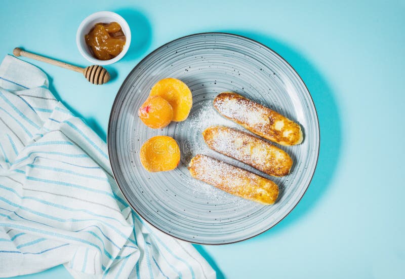 Cottage cheese pancakes with oats, syrniki and peach on blue background royalty free stock photo Cottage cheese pancakes with oats, syrniki and peach on blue background royalty free stock photo